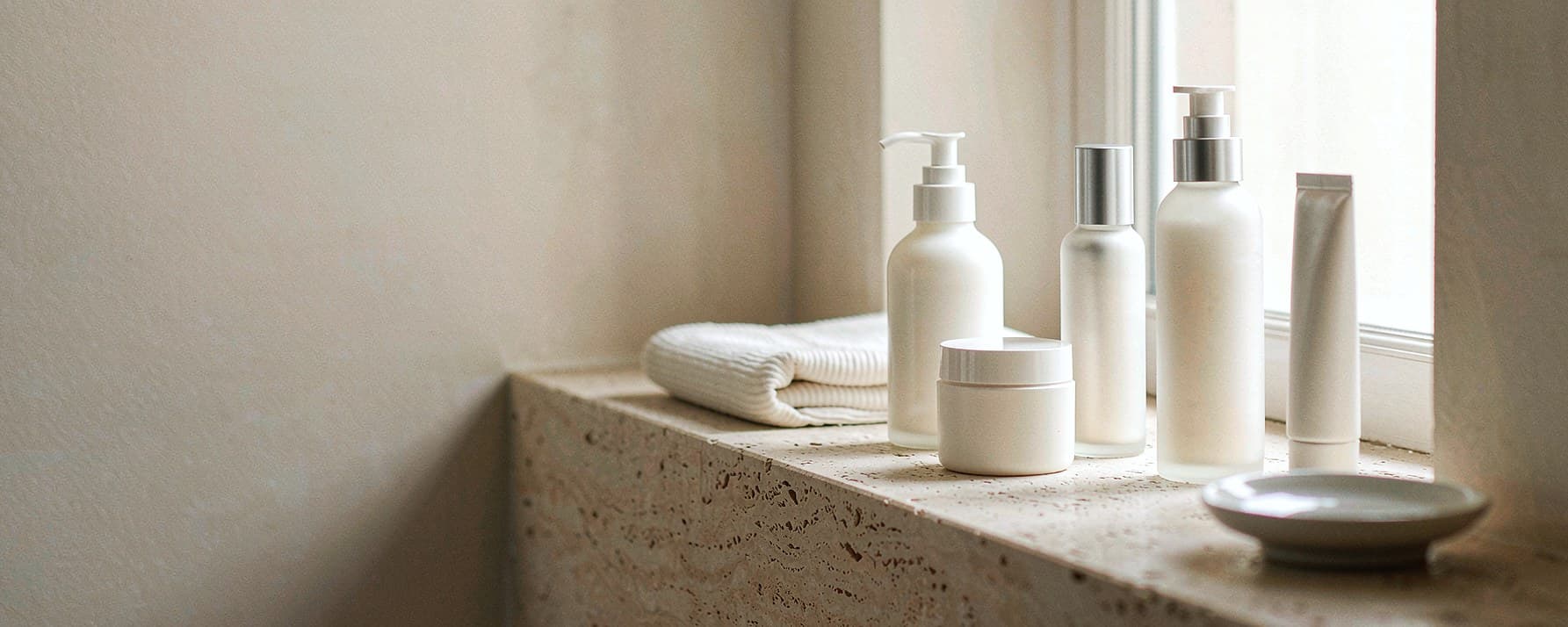 Skincare routine concept on a bathroom counter; products are illustrative